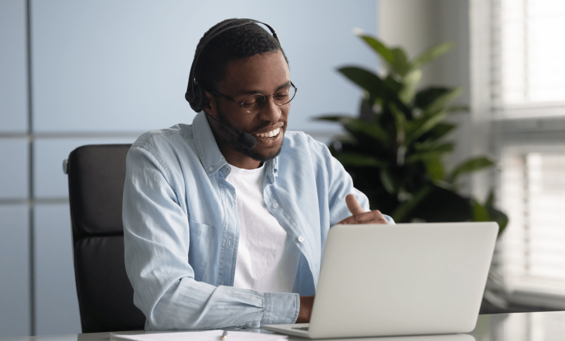 Smiling data analyst working on a laptop, representing the positive impact of hiring a data analyst for a healthcare company.