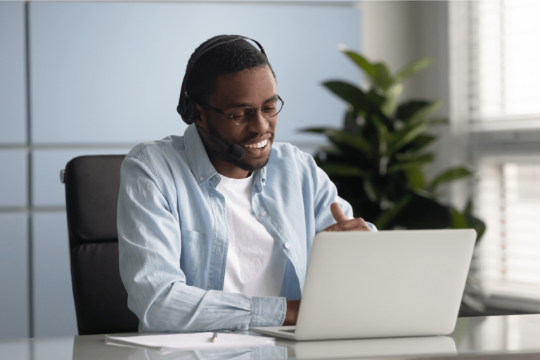 Smiling data analyst working on a laptop, representing the positive impact of hiring a data analyst for a healthcare company.