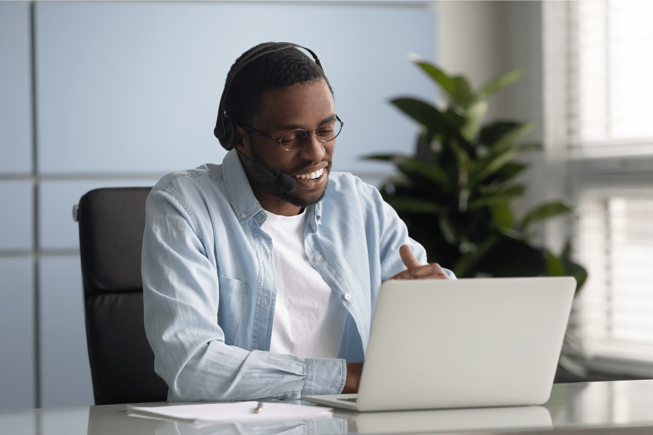 Smiling data analyst working on a laptop, representing the positive impact of hiring a data analyst for a healthcare company.