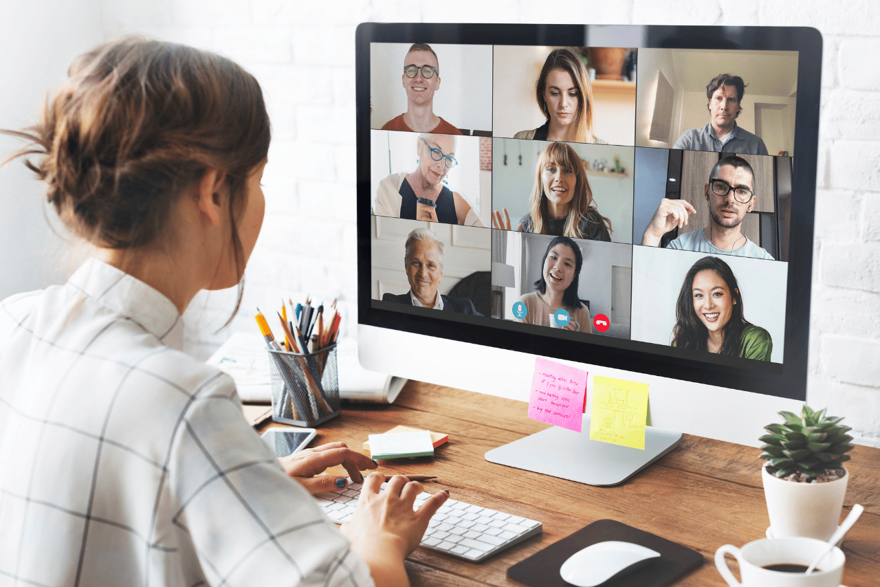 A woman in a virtual remote meeting, working from home on her laptop.