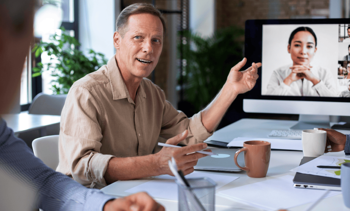 Manager leading a remote team through a video call on a laptop screen.