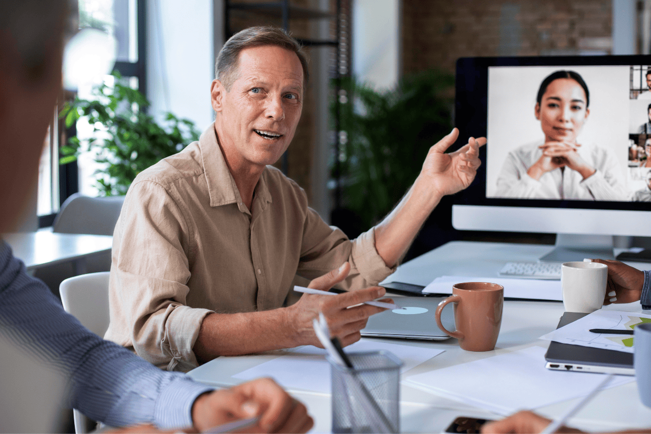 Manager leading a remote team through a video call on a laptop screen.