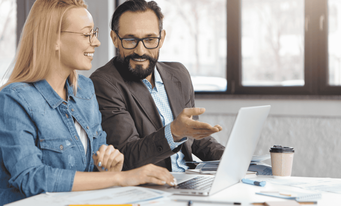 Two business professionals discussing offshore hiring strategies in an office setting.