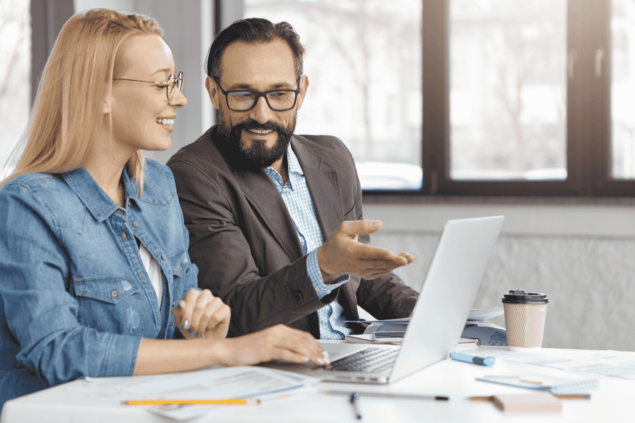 Two business professionals discussing offshore hiring strategies in an office setting.