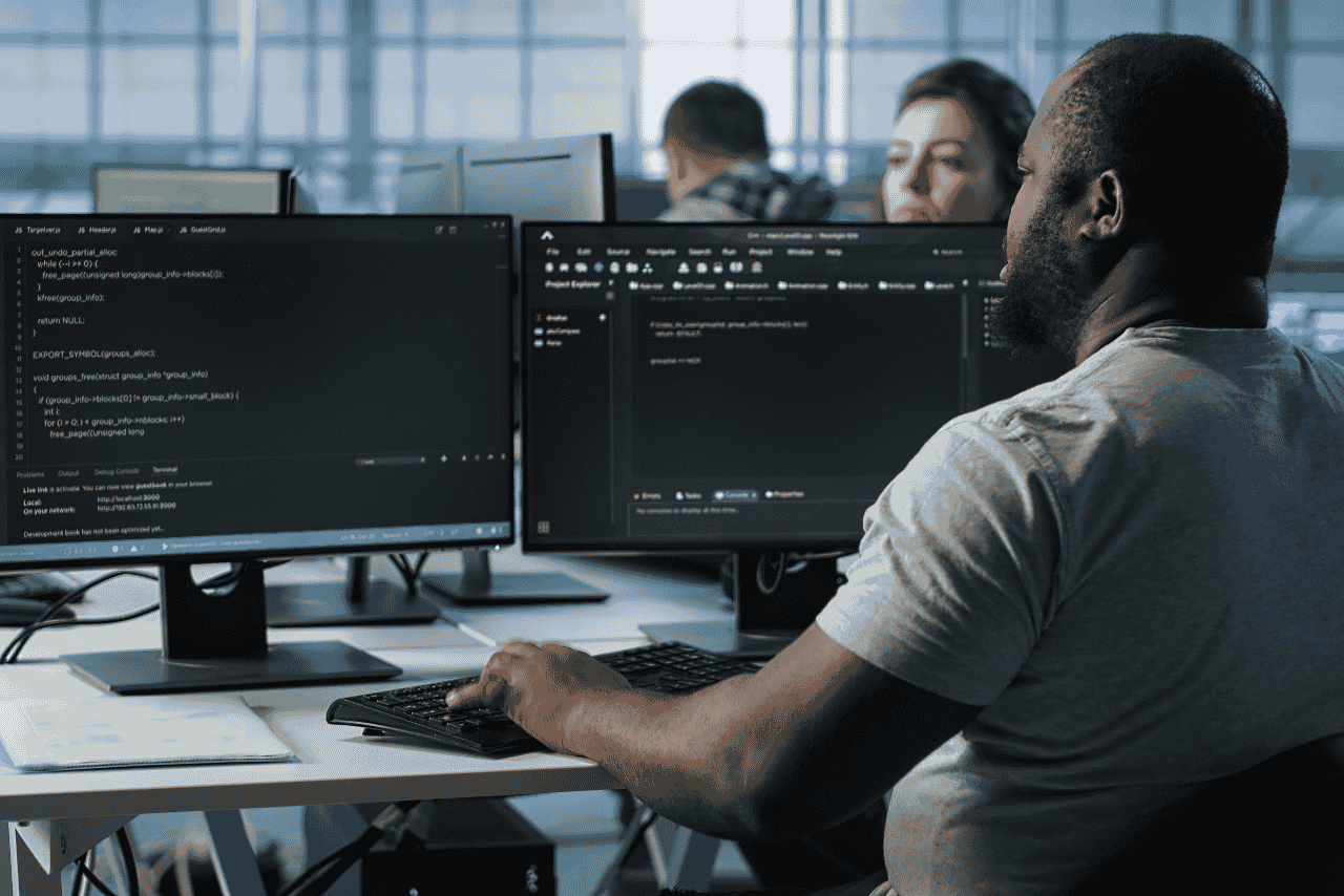 A remote full-stack developer working on website code from a laptop at home for a small business.
